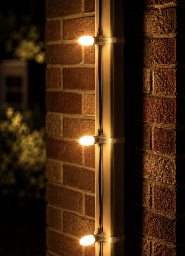 Warm-white lights mounted vertically with downspout clips
