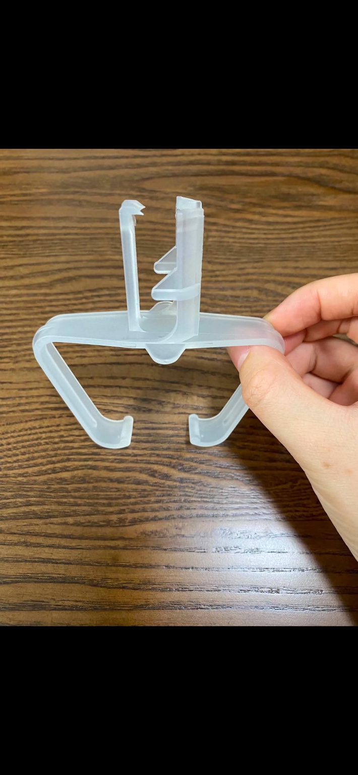 Translucent downspout clip held in hand